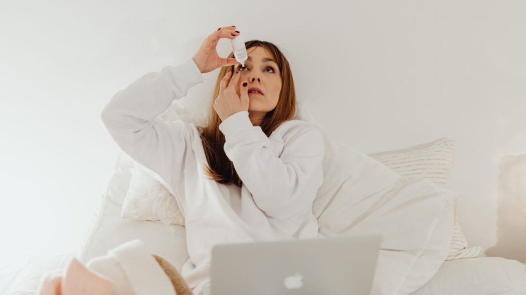 Woman applying eye drops