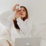 Woman applying eye drops