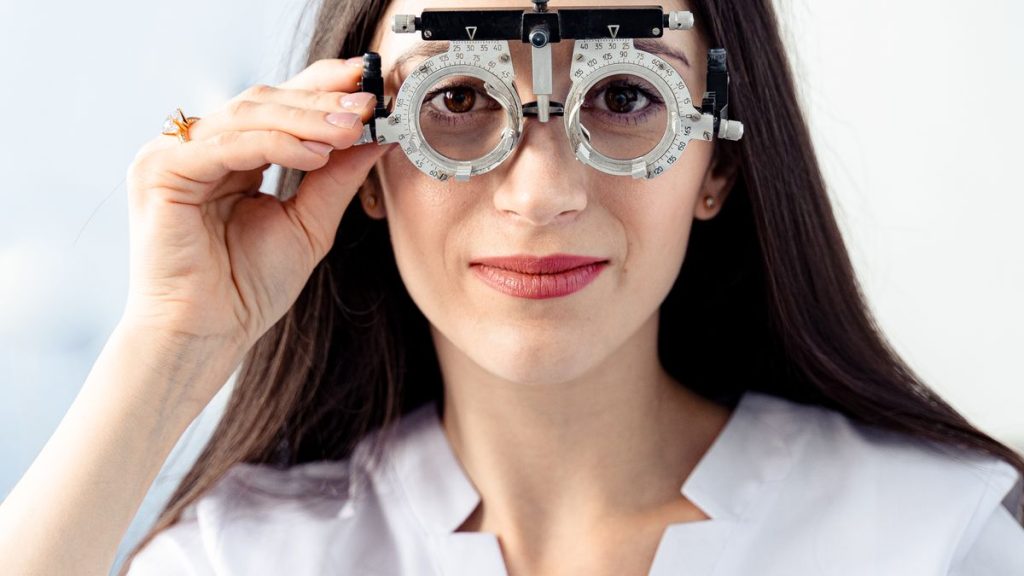 Optometrist examining a patient with a trial frame